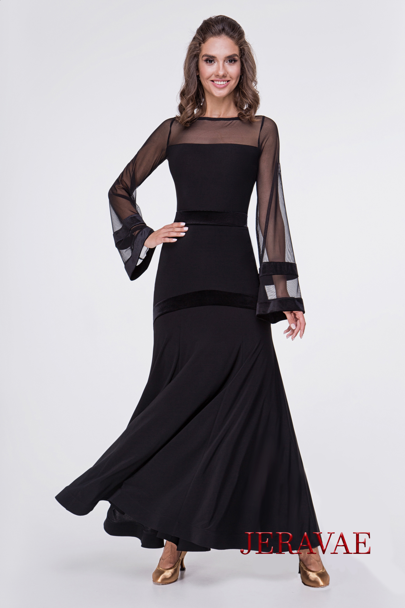 a dance model posing in a black dance top with mesh long sleeves across the top and velvet details at the wrist with the matching ballroom skirt with velvet details at waist