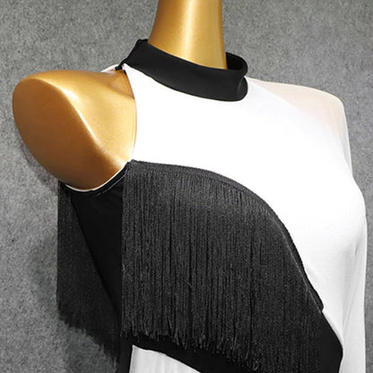 Close up of sleeveless side of black and white latin dress showing fringe accents and short black collar