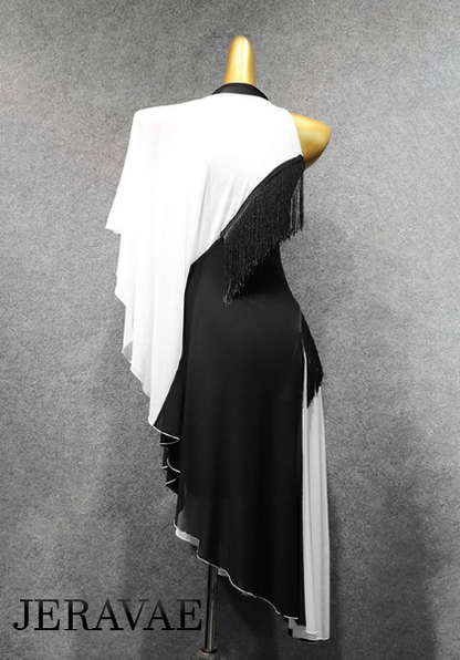 Back of latin dress showing flowy left sleeve connected to one of two white strips with a single black stripe separating the two with two pieces of fringe on right side.